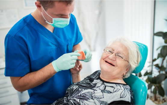 An image of a senior woman receiving dental care who&#039;s happy and smiling.
